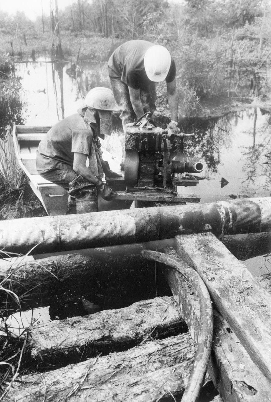 A cleanup crew from Norfolk worked on an oil spill in South Richmond. Fuel oil had escaped from an open valve at Little Oil Co. on Commerce Road, 1975.