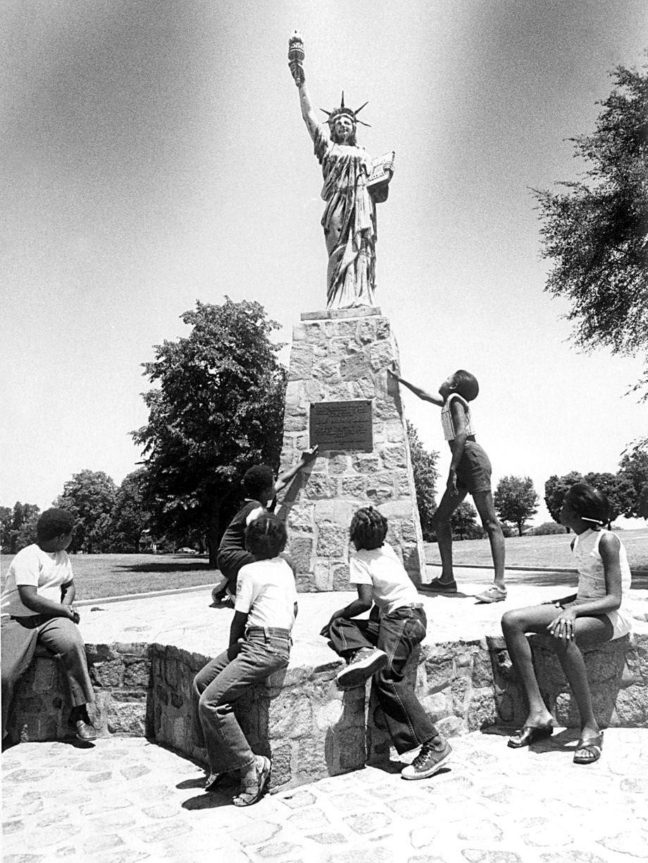 Children sat around the small Statue of Liberty in Chimborazo Park in Richmond, 1975.