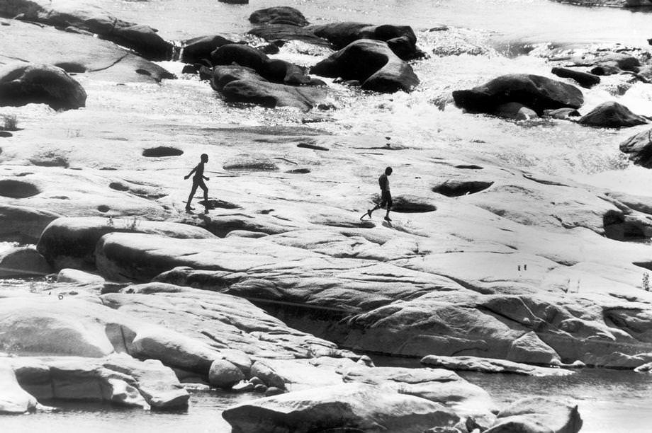 Two boys walked along the rocks in the James River near the Lee Bridge in Richmond, 1979.