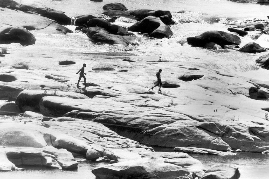Two boys walked along the rocks in the James River near the Lee Bridge in Richmond, 1979.