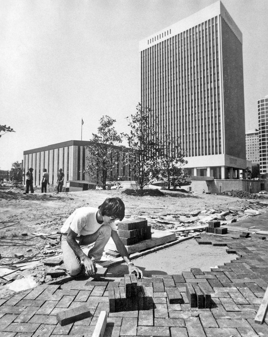 Terry Woo set bricks for a walkway as construction of Kanawha Plaza in downtown Richmond continued, 1979.