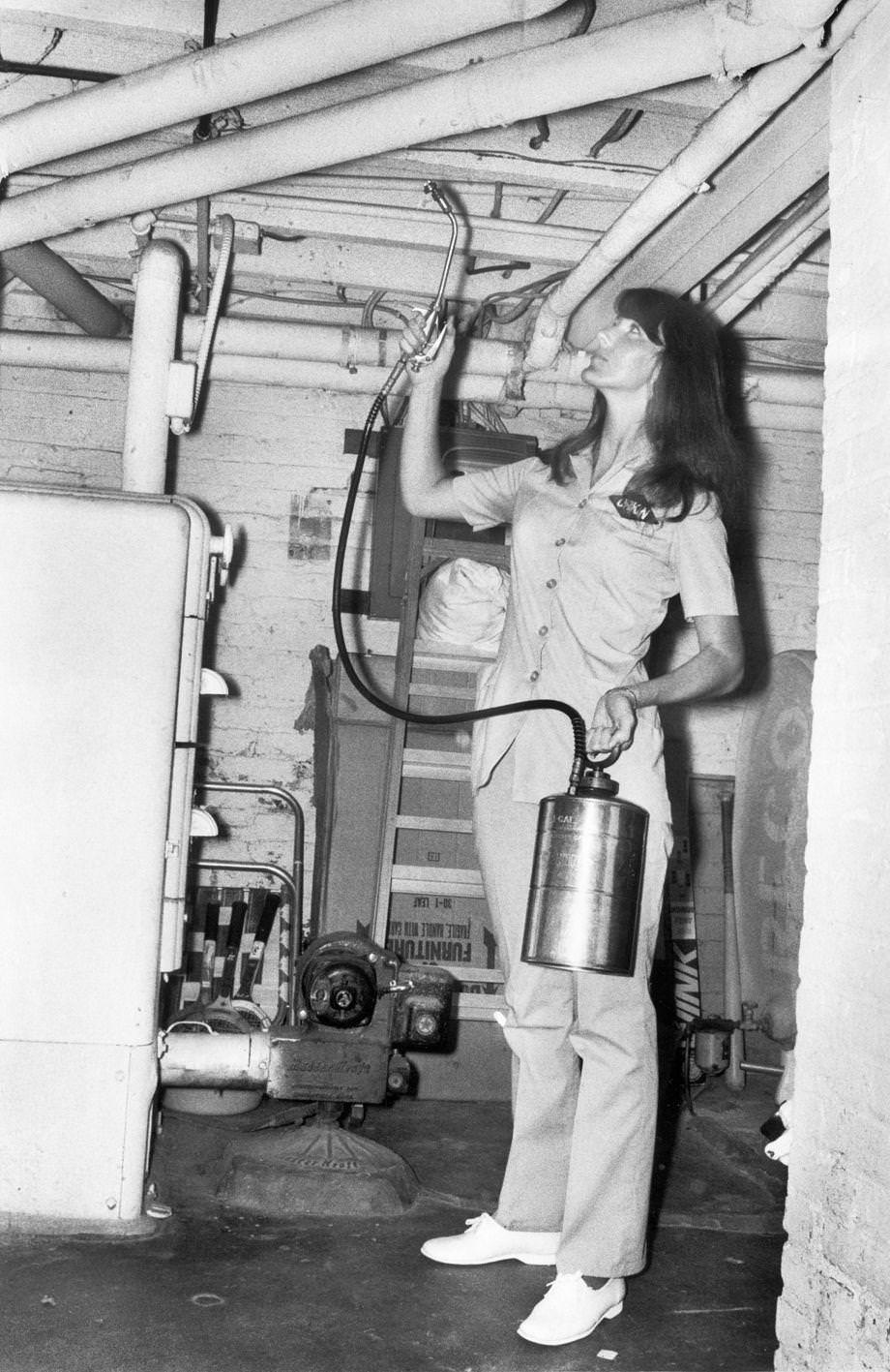 An exterminator Linda Summerlin sprayed pest control in a customer’s basement, 1973.