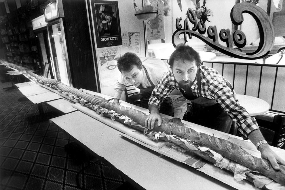 Coppola’s Deli owner Joe Coppola (right) and manager Bill Gerloff carefully assemble a 40-foot Italian hero in the Carytown eatery, 1989