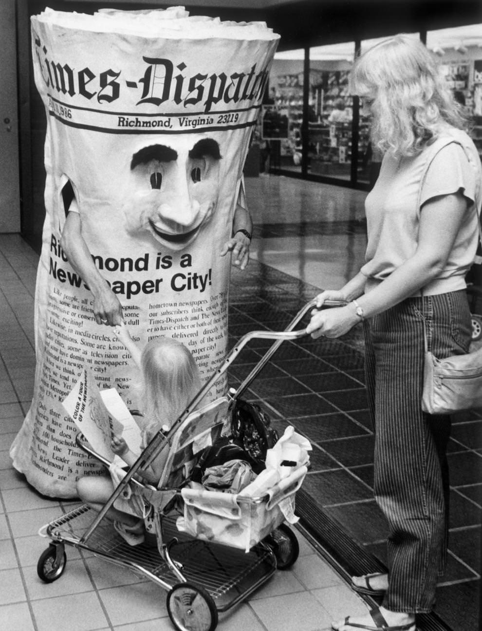 “Mr. Newspaper” greeting a young girl and her mother at a Richmond-area mall, 1986.