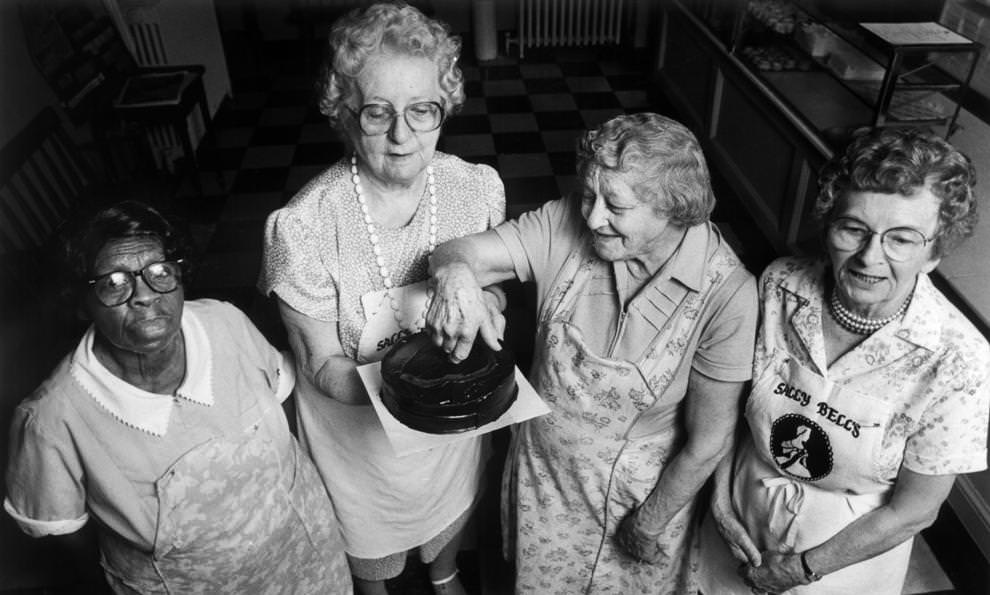 Veterans at Sally Bell’s Kitchen in Richmond – Lucille Zimmerman (from left), Mary Newcomb, Dorothy Daniels and Anne Mulfinger – posed with one of the countless cakes they had prepared over decades of working together, 1990