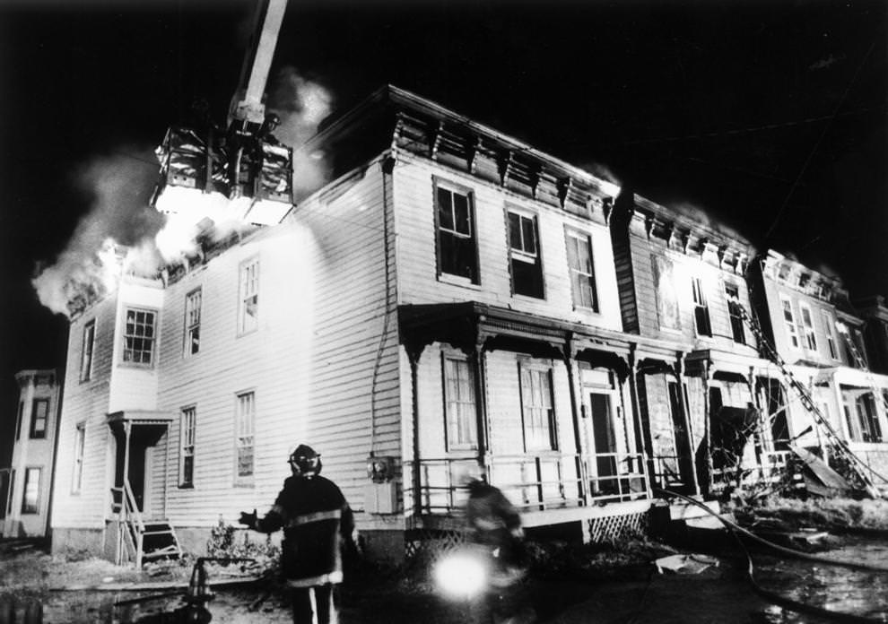A city Fire Bureau aerial ladder truck poured water onto the flaming row houses in 16-degree temperatures last night, 1992.