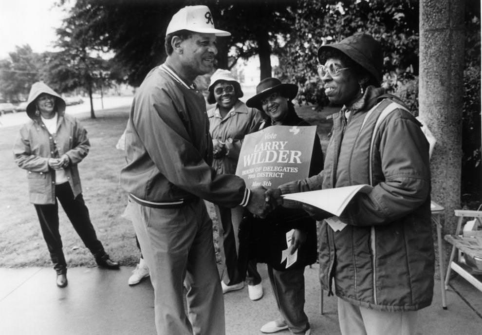 Richmond Mayor Walter T. Kenney clasped the hand of Marian Brown yesterday outside Mosby Middle School, as supporters Sharon Menefee (center) and Laura Miles smiled their greetings, 1992