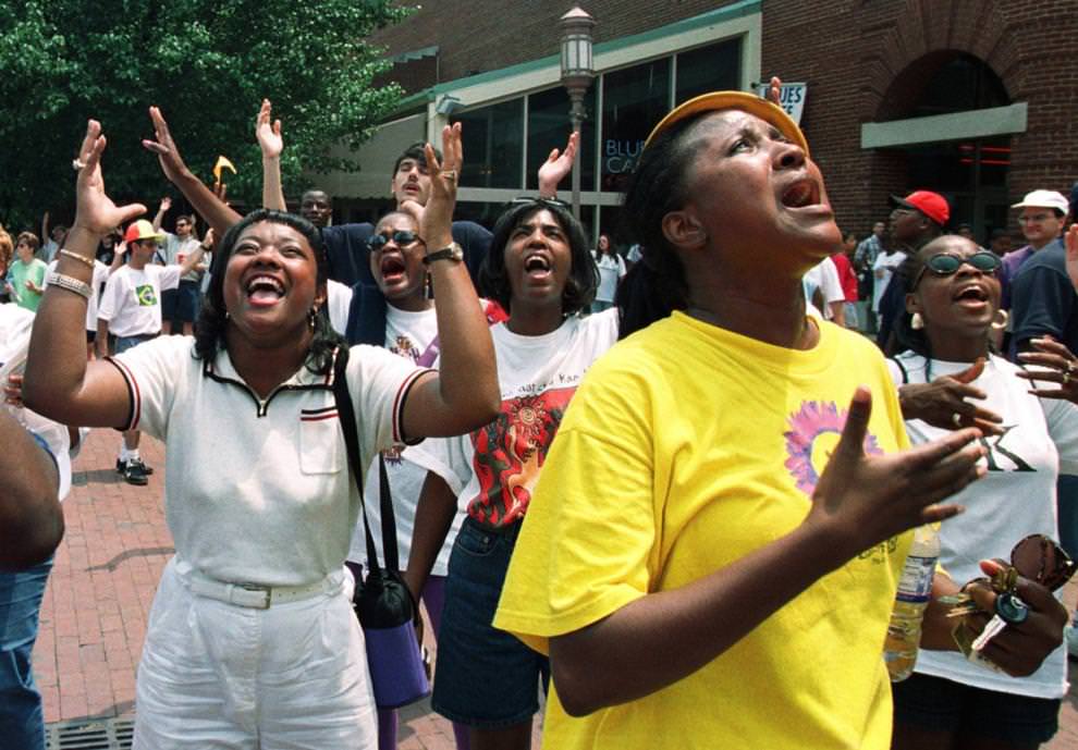 After walking in the March for Jesus, Sandra Brown (left) and Marjilette Brown (in yellow) pray with hundreds of others in Festival Park, May 30, 1998.