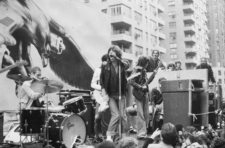 Charlie Watts, Mick Jagger, and Bill Wyman perform on a flatbed truck on Fifth Avenue, New York City, 1975.