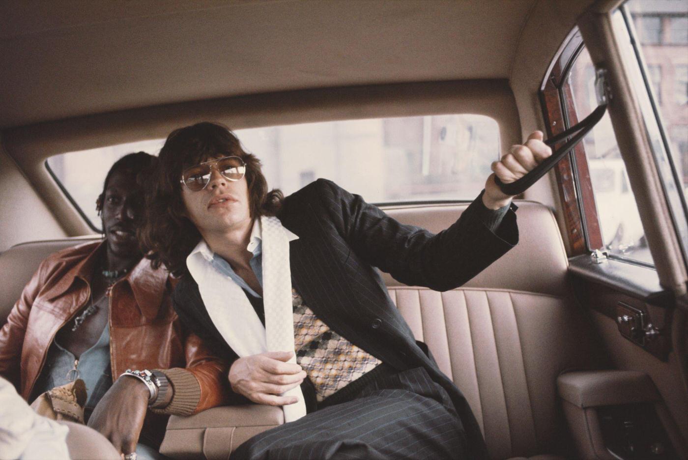 Mick Jagger seated in a limousine car during the tour, June 1975.