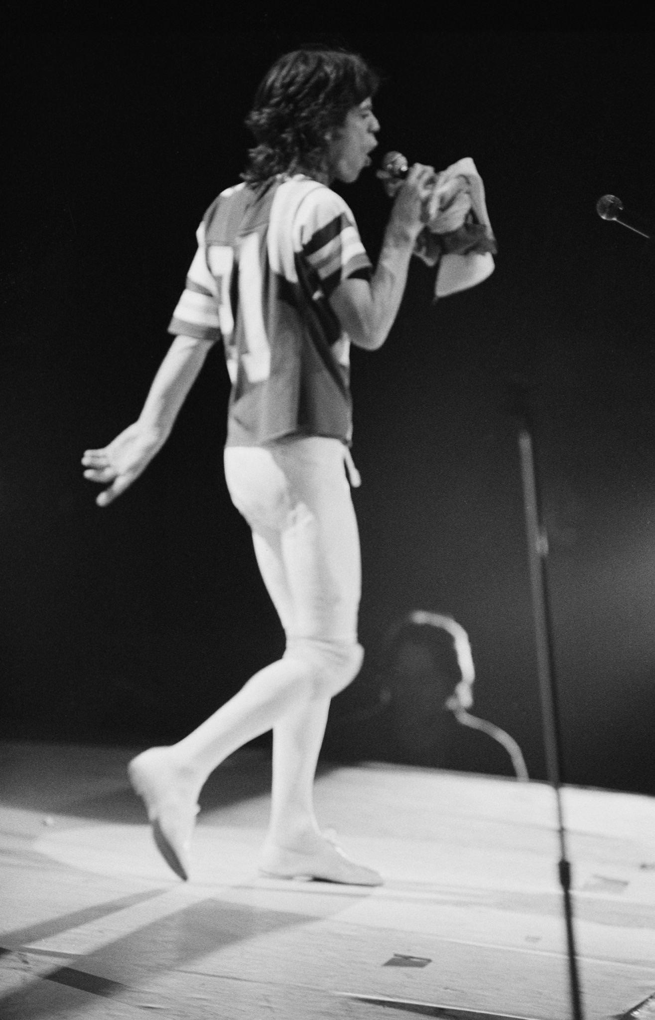 Mick Jagger, wearing an American football shirt, performs with The Rolling Stones , 1975.