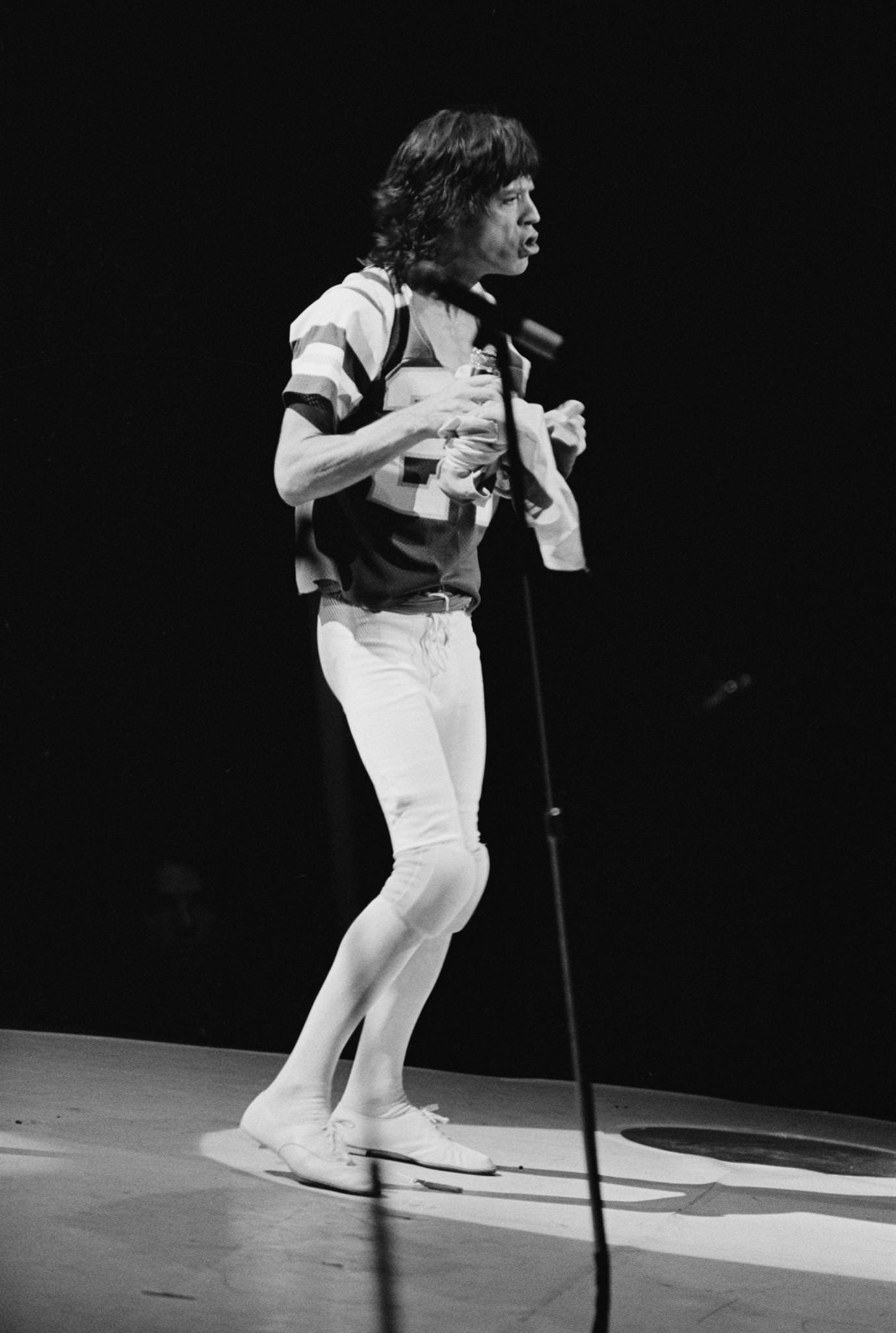 Mick Jagger, wearing an American football shirt, performs with The Rolling Stones , 1975.