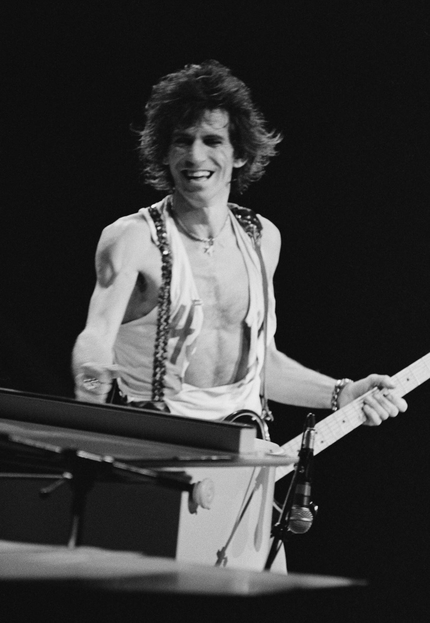 Keith Richards, wearing a ripped vest, performs with The Rolling Stones , 1975.