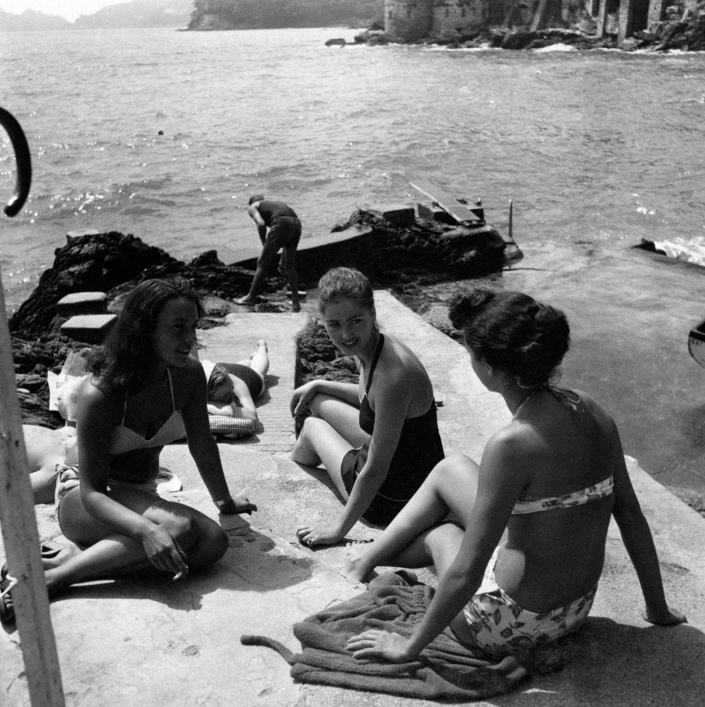 Girls in swimsuits chatting by the sea on the Italian Riviera, 1951.