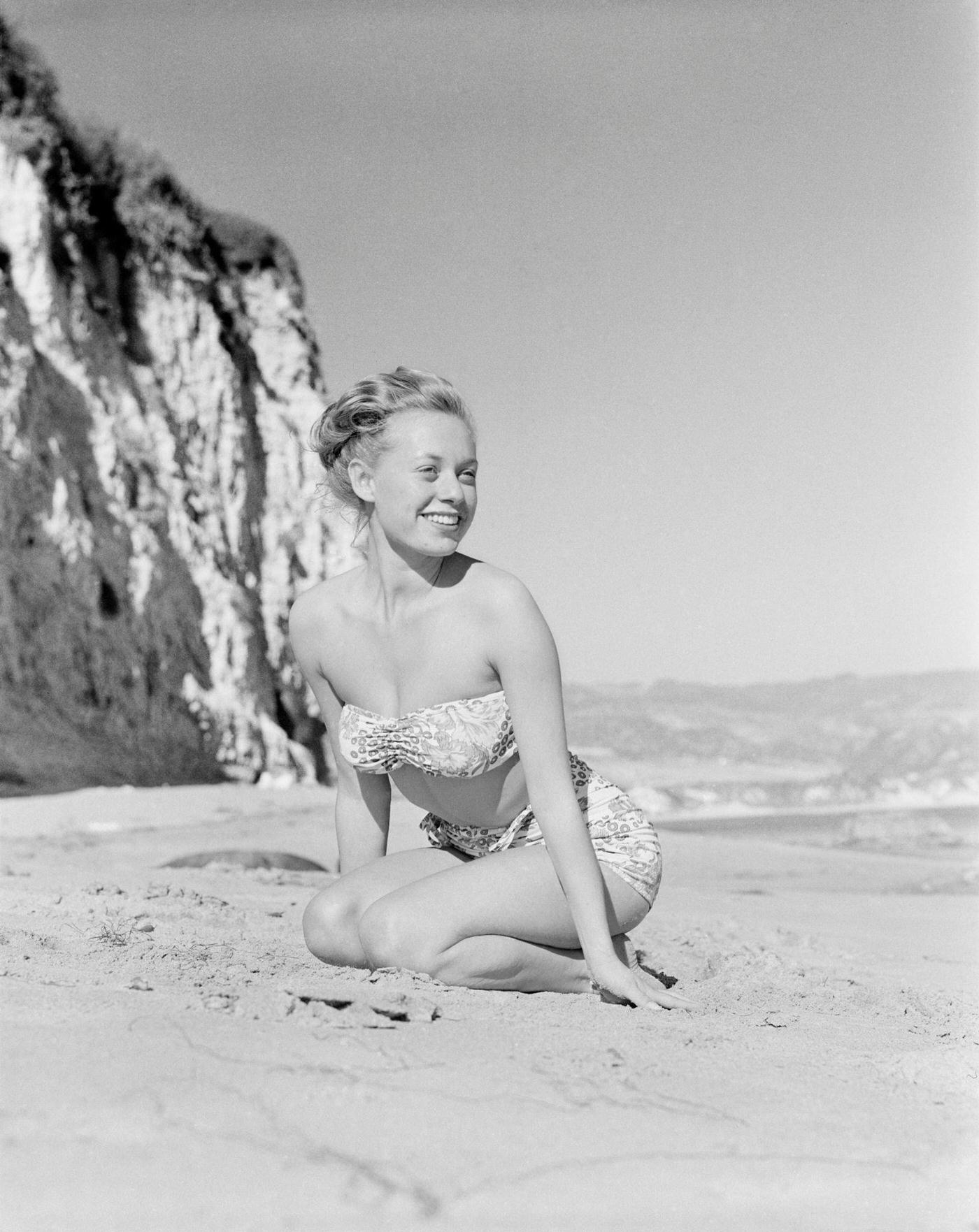 Model Fran Cooper wearing a patterned bikini on the beach, 1948.
