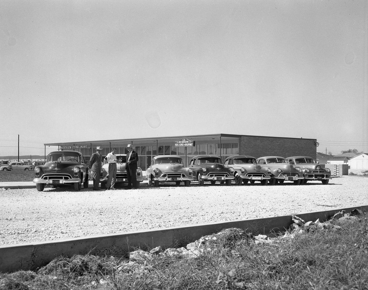 Display of Autos with Men Standing Near, 1950