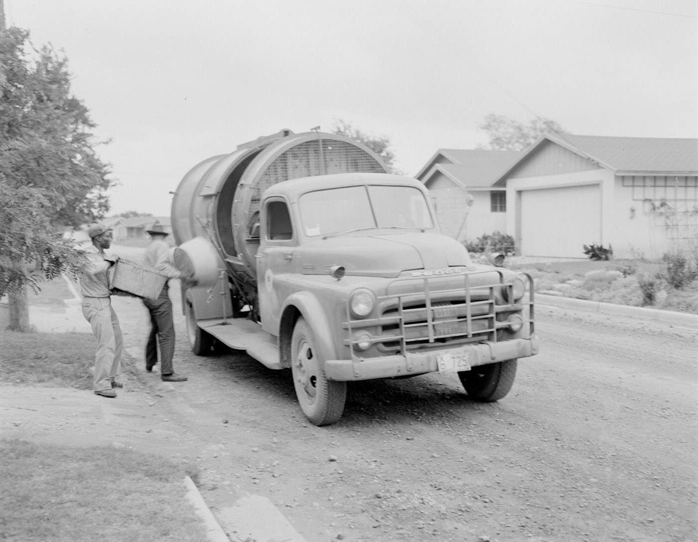Sanitation Workers Emptying Containers into Truck, 1953.