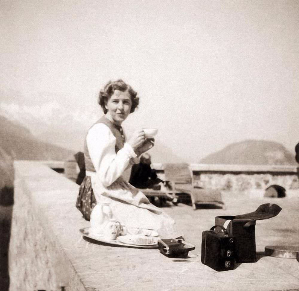 Eva Braun sits on the terrace at Berghof, Hitler's home in the Alps, 1942. A photography buff, she took many photos of daily life at Berghof; note the camera by her side. But her life would not long remain so idyllic.