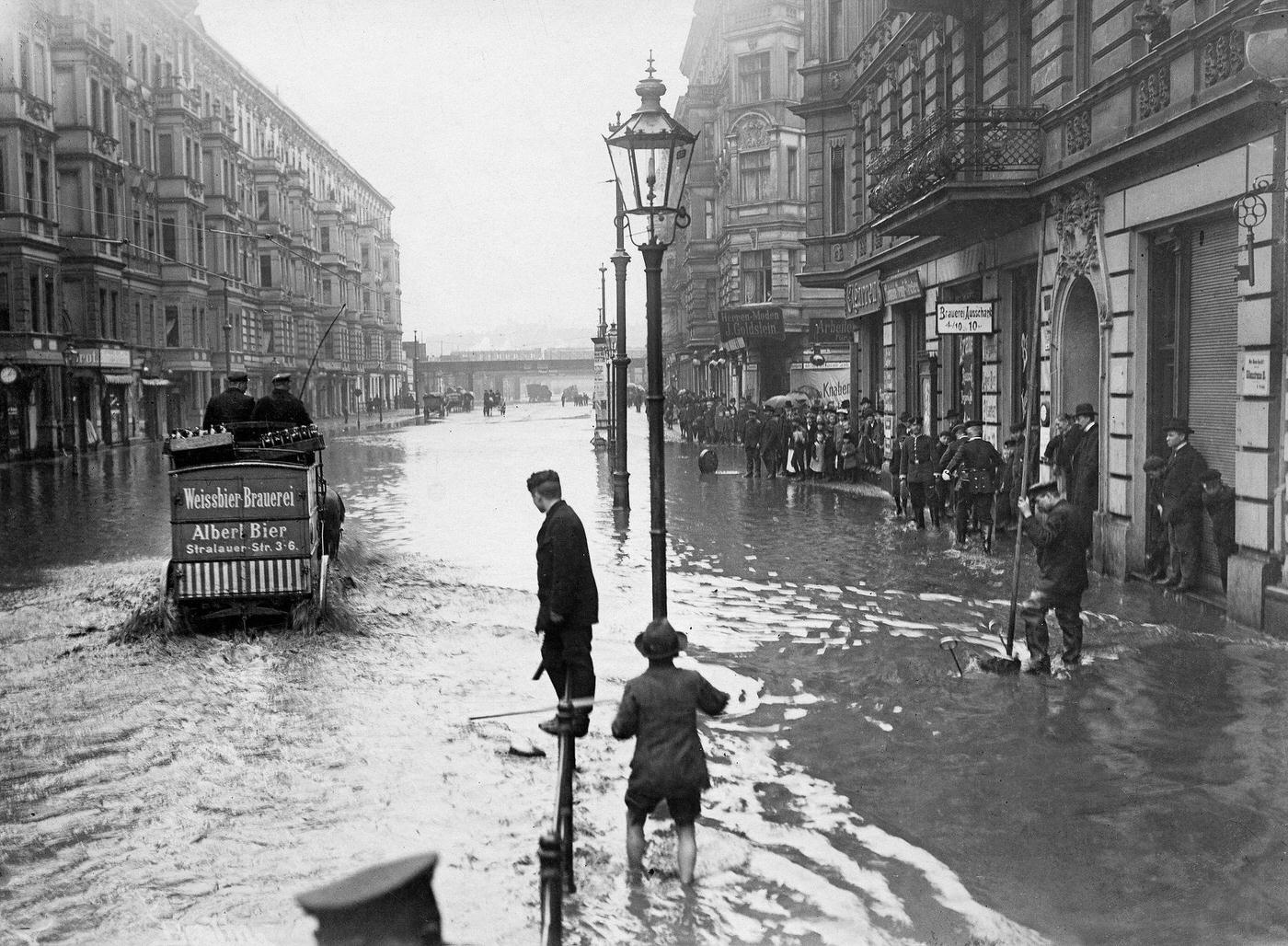 Berlin: People on submerged street after deluge, Germany, 1902.