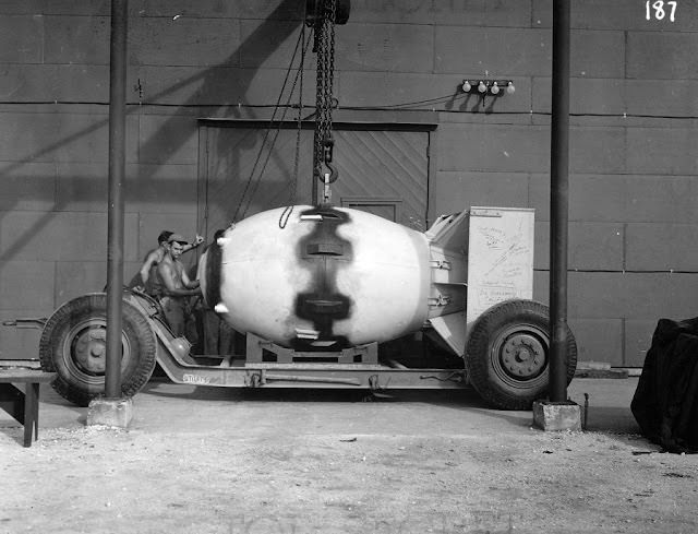 Fat Man is lowered on to a transport dolly for the trip to the airfield. Note the signatures on the tail assembly.