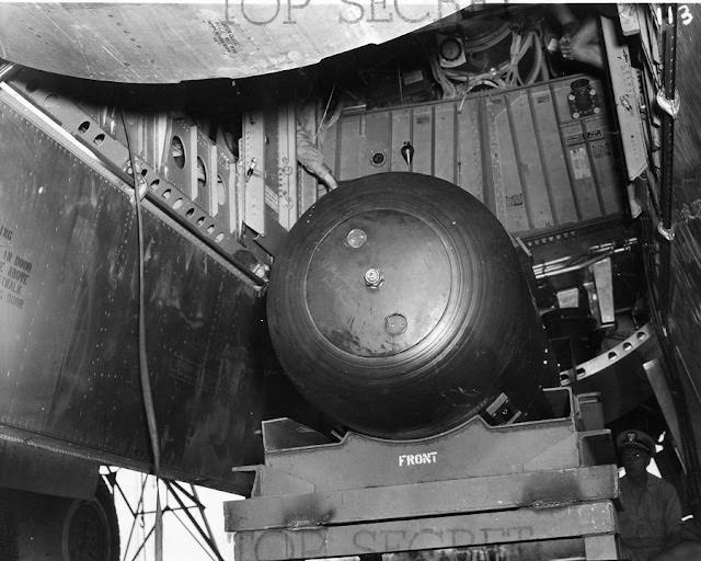 Little Boy is lifted via a hydraulic lift into the Enola Gay.