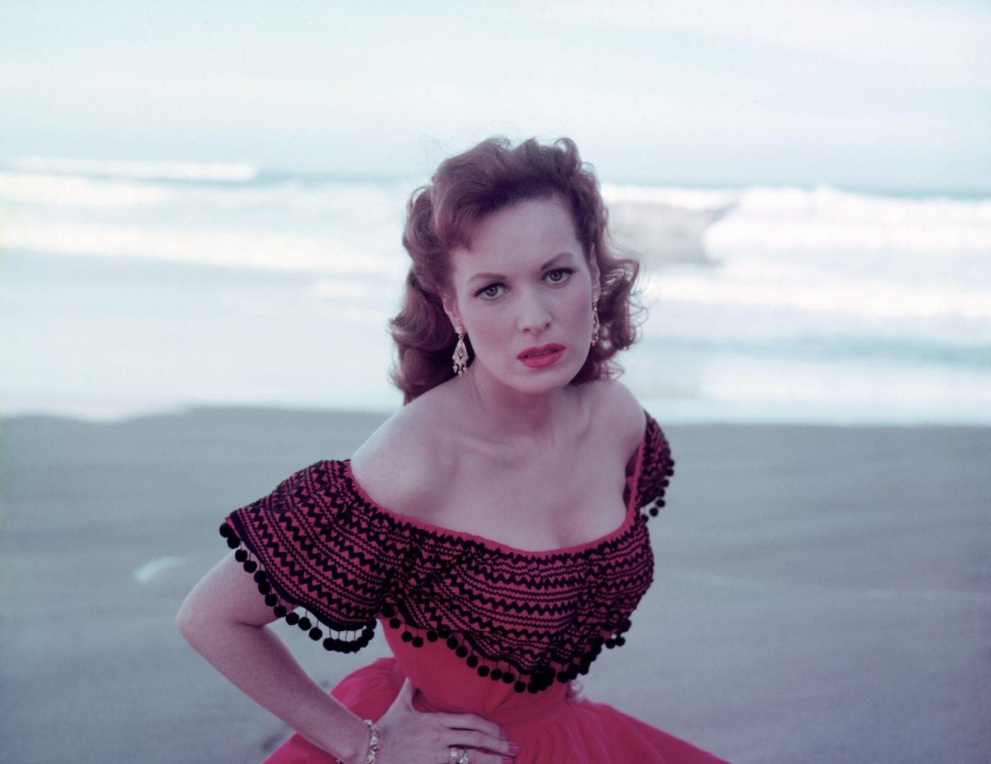 Maureen O'Hara in a red dress on the beach, Lisbon, Portugal, 1955