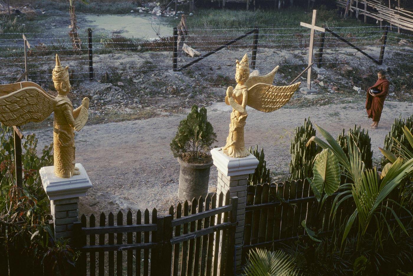 Nyaung Shwe, Myanmar - Buddhist Monks Passing Statues of Angels, 1980s