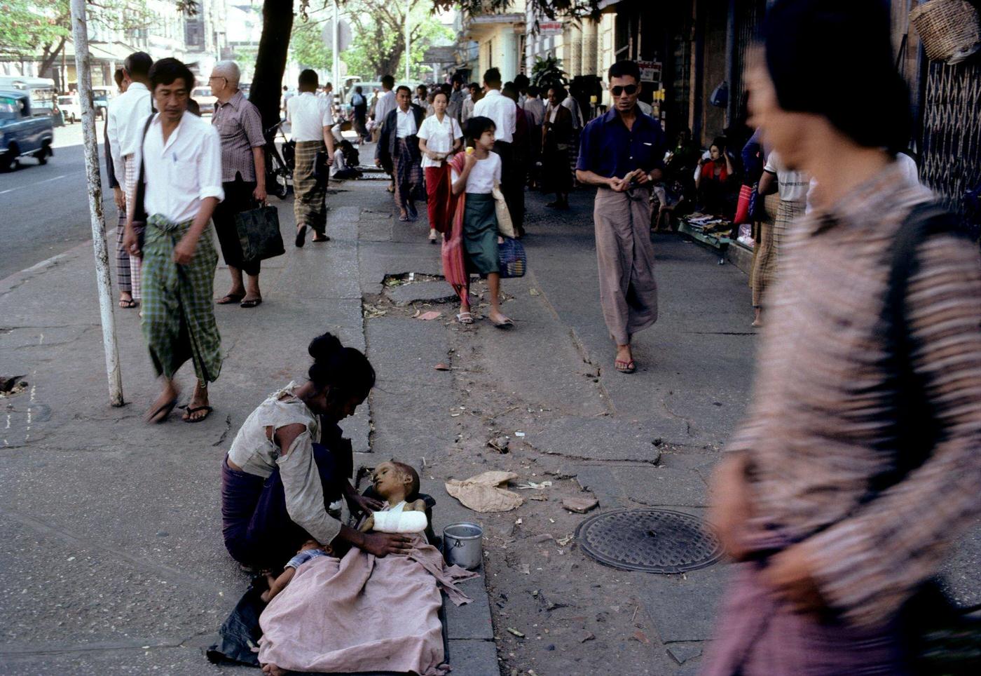 Poverty-Stricken Mother Comforts Malnourished Injured Child While Begging in Rangoon, Burma, 1985