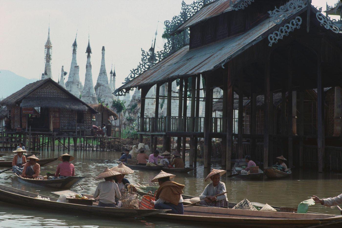 A floating market on Inle Lake in Burma, with a temple in the background, 1988.