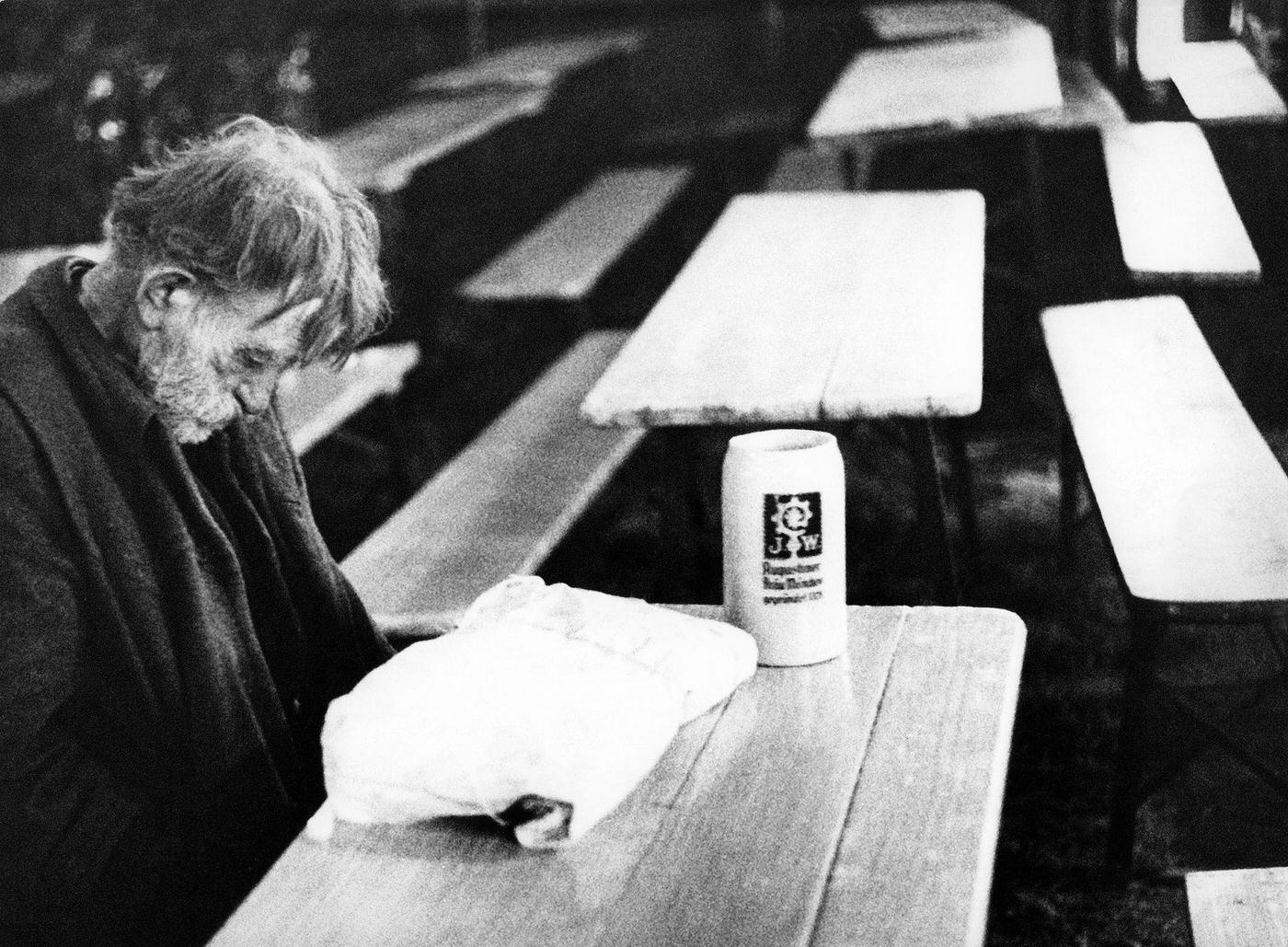 Man sleeping in front of stein in beer tent, 1968.