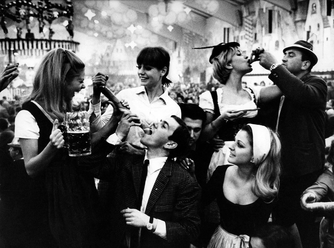 Young people drinking beer in a beer tent, 1969.