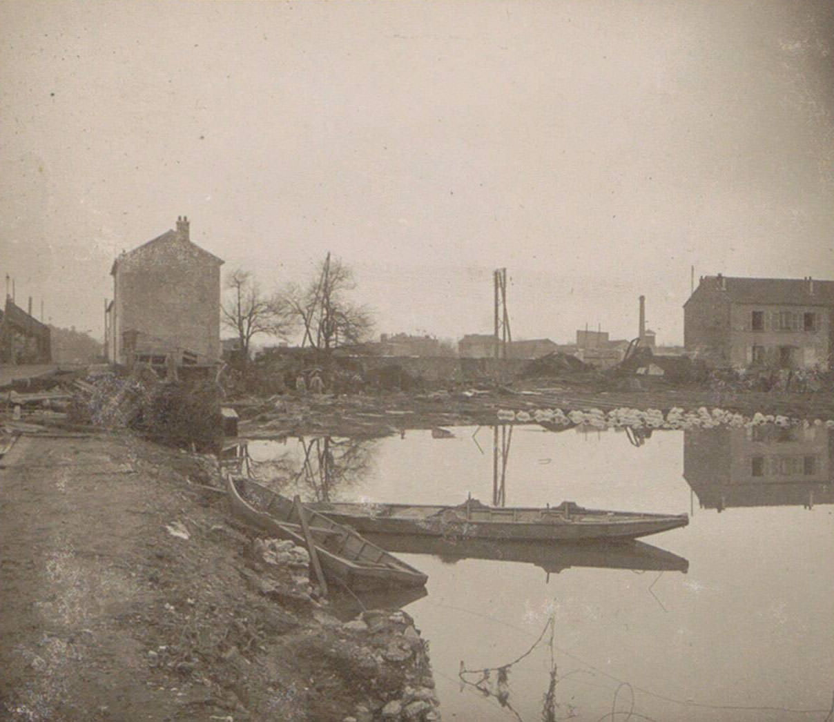 Boat and houses in a flooded suburb of Paris. Part of photo album of the 1910 flooding in Paris and suburbs.