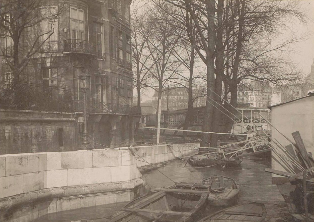 Boats along a quay during Paris flood. Part of photo album flooding Paris and suburbs 1910.