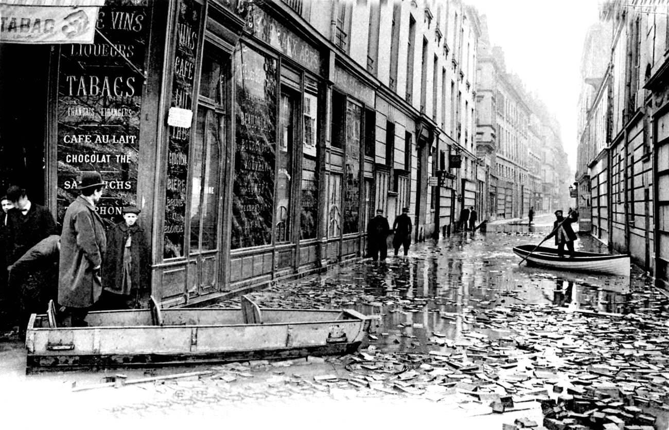 10th-century flooded Paris street with rowing boats, France, 1910.