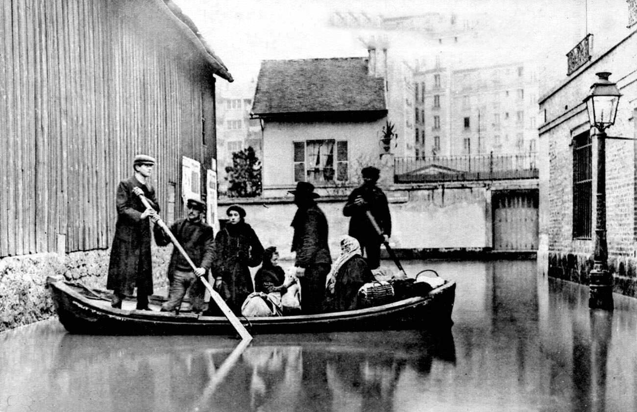 10th-century flooded Paris street with rowing boat, France, 1910.