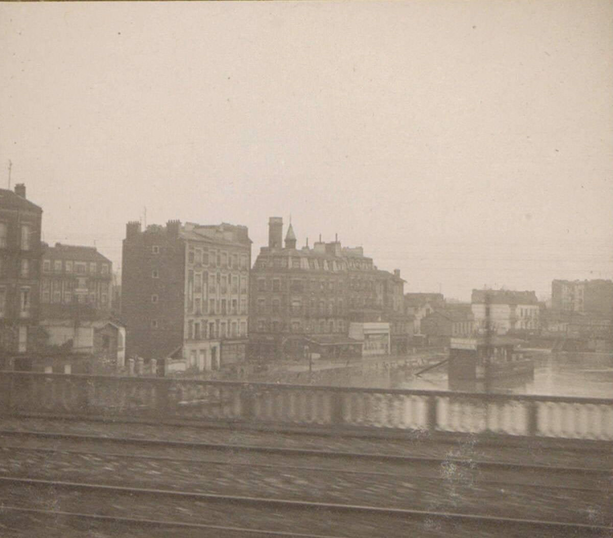 Flooded street and buildings during Paris flood, seen from the train. Part of the photo album flooding Paris and suburbs 1910.
