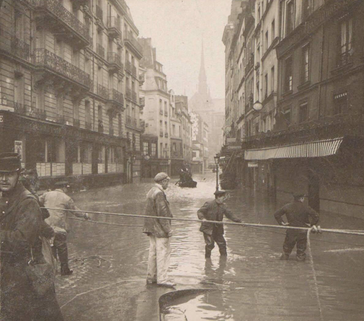 Men performing rescue during Paris flood. Part of the photo album flooding Paris and suburbs 1910.