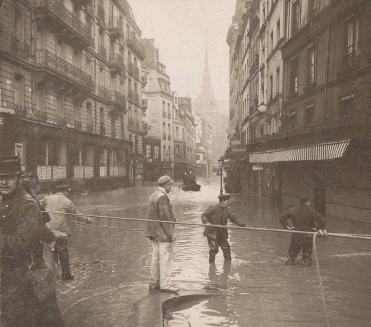 Men performing rescue during Paris flood. Part of the photo album flooding Paris and suburbs 1910.