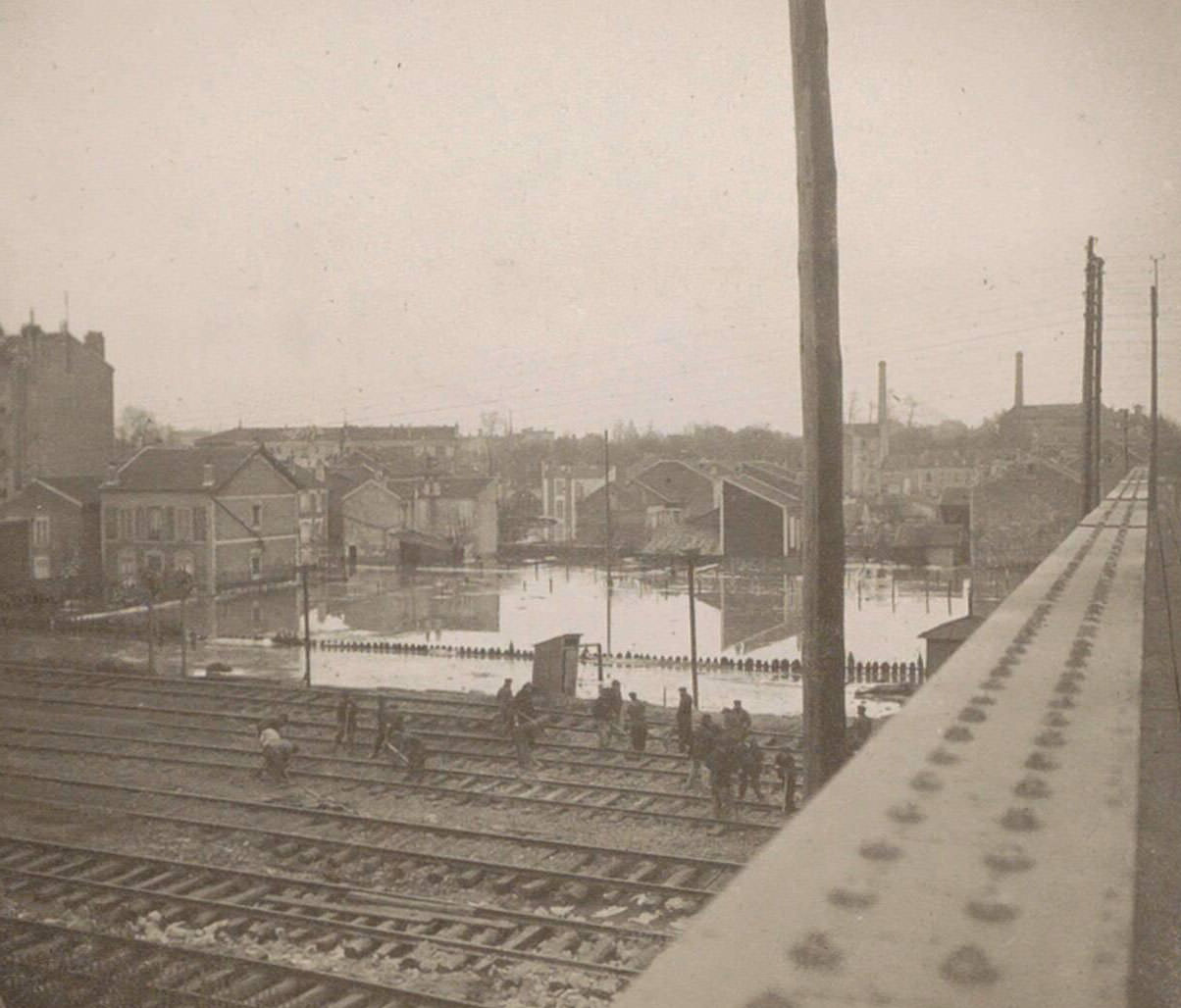 Work on railways during Paris flood, seen from the bridge. Part of the photo album flooding Paris and suburbs 1910.