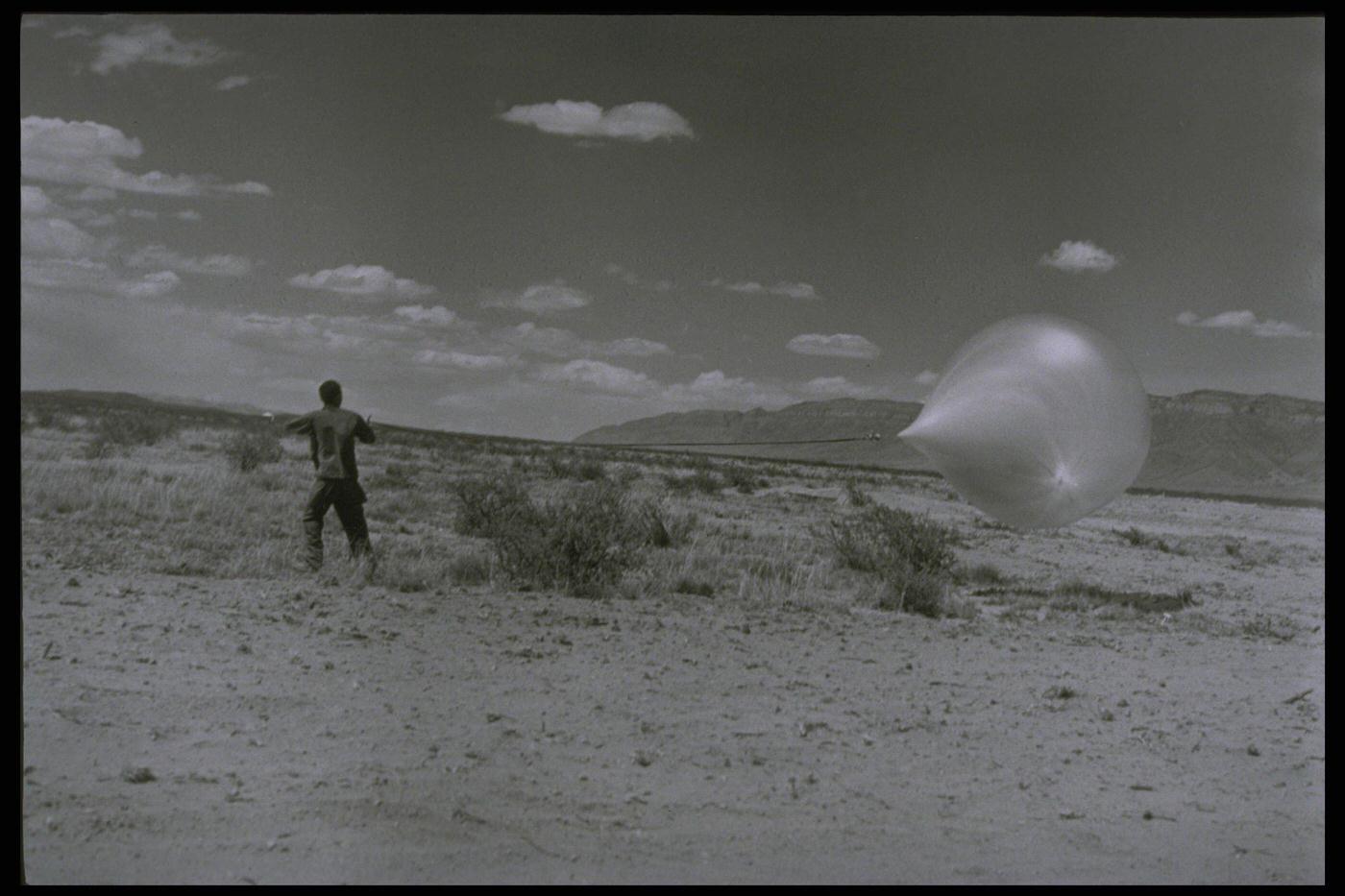Man Holding Research Balloon in Desert, New Mexico