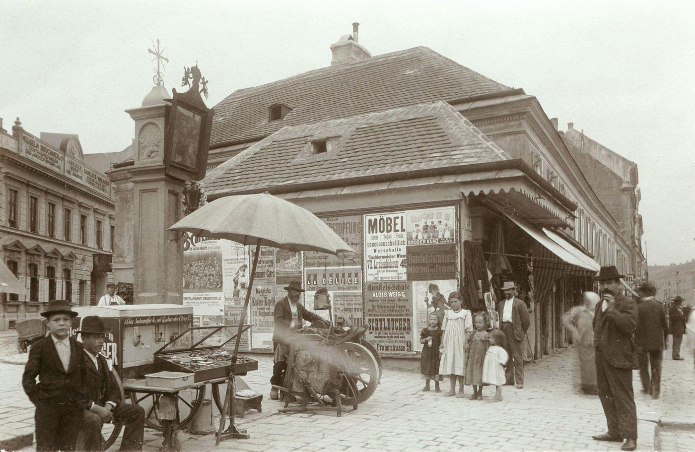 A knife grinder and pedestrians at the pest column, Landstrasser Hauptstrasse (street), Vienna, August 1903