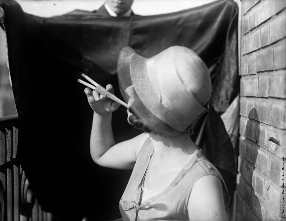 A woman smoking two cigarettes simultaneously with an elegant cocktail cigaratte holder, 27th July 1931