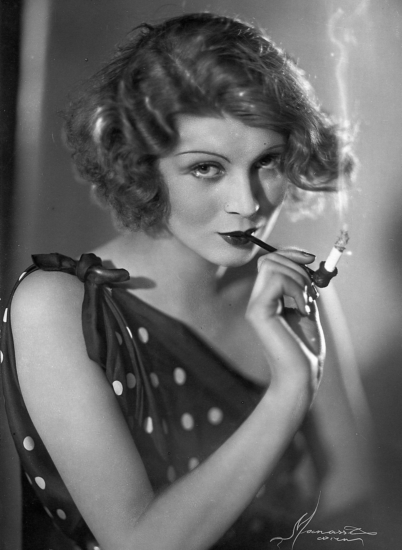 Pipe smoking diva, brunette photomodel, seductive pose, 1930.