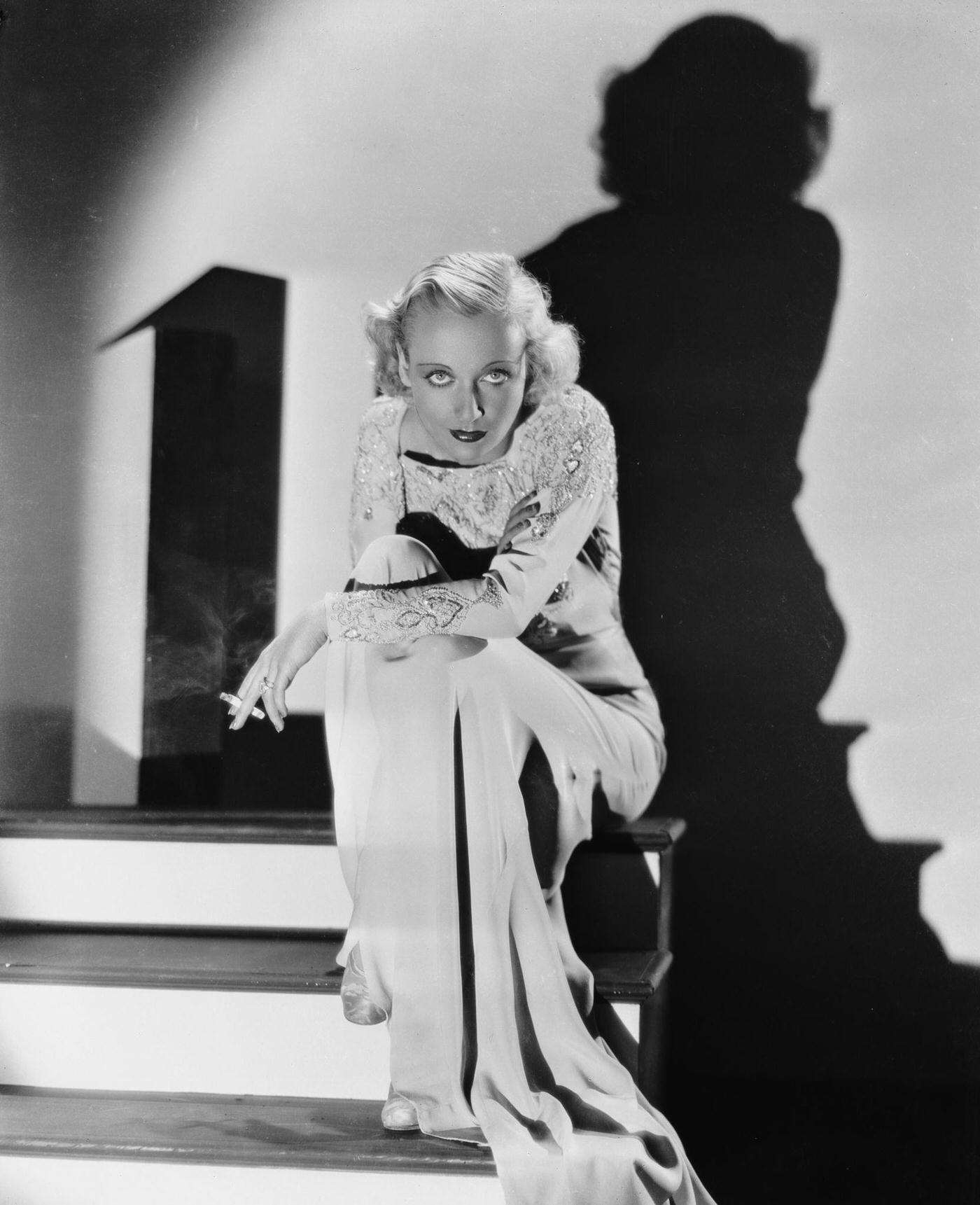 American film actress Carole Lombard casts a dramatic shadow against the wall, 1942.