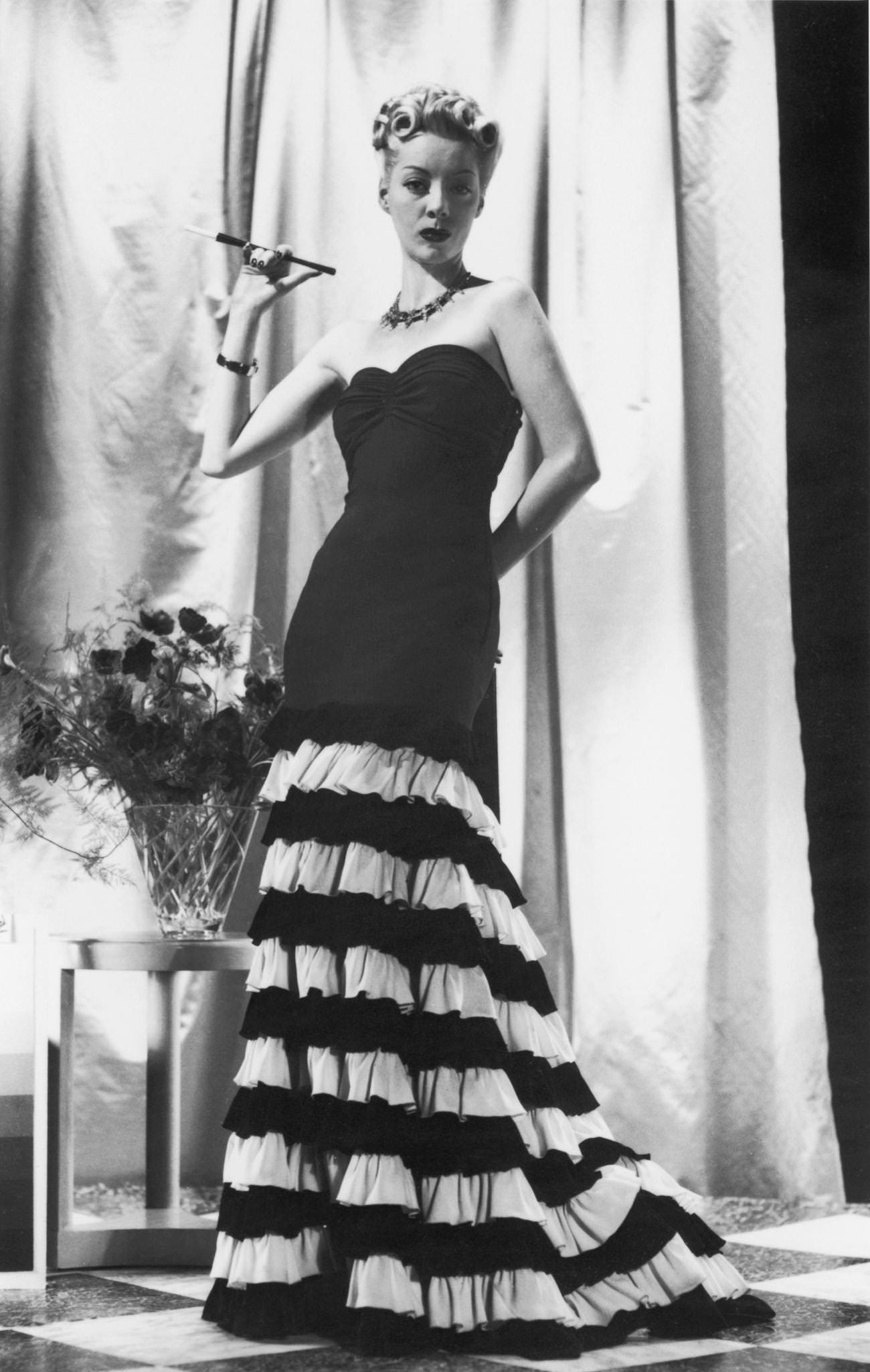 A woman in a long, ruched, two-tone evening gown, 1935