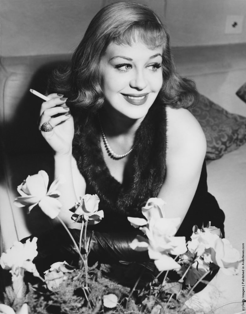 Hildegard Knef at her London hotel. 18th November 1952. She is modeling the outfit she plans to wear to the premiere of her latest film, The Snows of Kilimanjaro.