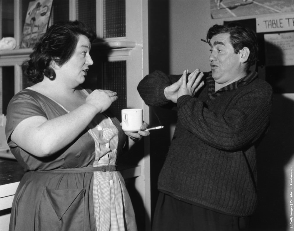 English actor and comedian Tony Hancock shares a joke with actress Hattie Jacques during a break from the “Hancock’s Half Hour” rehearsals. 21st October 1959.