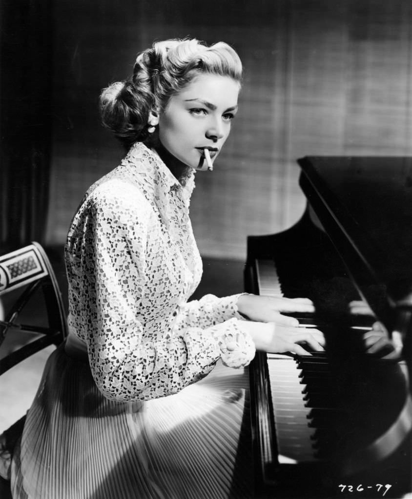 Lauren Bacall smoking as she plays piano in 'Young Man with a Horn,' California, 1950.