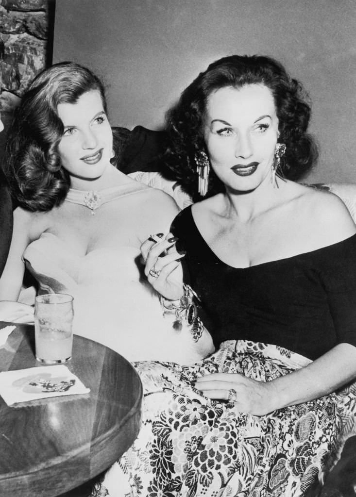 French actress Corinne Calvet smoking a cigarette with Czechoslovakian actress Florence Marly at the World Film Favourite Festival, California, 1951.
