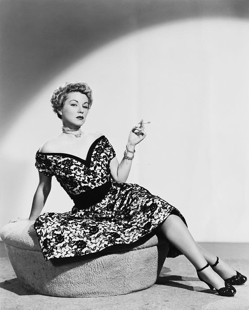 Actress Claire Trevor smoking a cigarette as Connie Williams in the film "Hoodlum Empire," 1952.